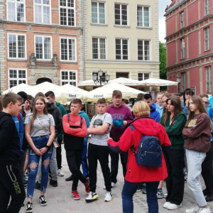 Uczniowie słuchają przewodnika na Starym Mieście w Gdańsku.