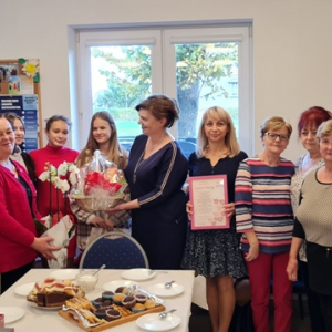Pani Dyrektor Małgorzata Budna składa życzenia członkom Klubu Seniora oraz przekazuje słodką niespodziankę