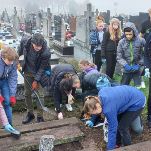 Grupa uczniów pod opieką p. Wojtka w trakcie porządkowania bezimiennego grobu