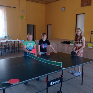 Natalia , Maciek i Wiktor szykują się do gry w ping ponga.