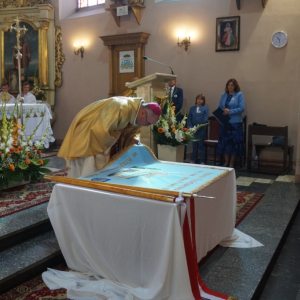 Biskup całuje poświęcony sztandar 