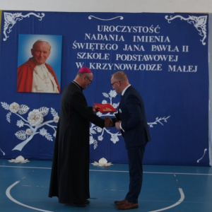 Biskup przekazuje p. Dyrektorowi Dekret zezwalający na nadanie szkole imienia Świętego Jana Pawła II.  