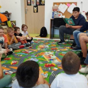 Uczniowie z klasy VII czytają przedszkolakom z grupy "Liski"