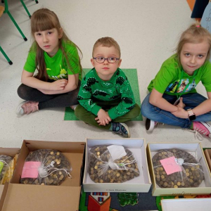 Przedszkolaki pomagają pakować zebrane monet.