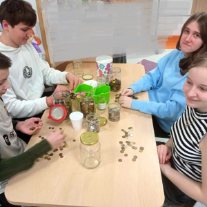  Uczniowie z Samorządu Uczniowskiego segregują i liczą zebrane monety.