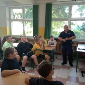 Uczniowie klasy czwartej podczas spotkania z policjantem na temat bezpiecznej drogi do szkoły.
