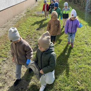 Najmłodsi przedszkolacy sprzątają teren wokół szkoły