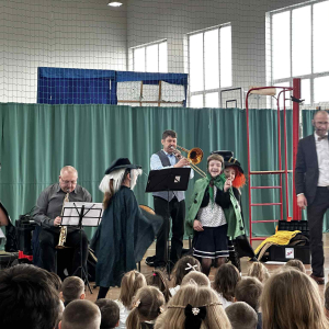Dzieci z uwagą słuchają gry na puzonie.