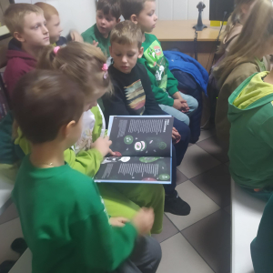 Dzieciaki z zainteresowaniem oglądają książeczkę.
