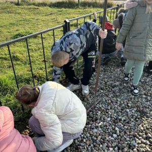 Uczniowie klasy czwartej porządkują przy pomniku 40-tu pomordowanych
