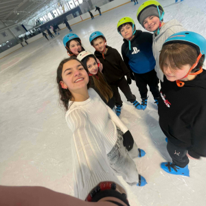 grupka uczniów na lodowisku pozuje do zdjęcia