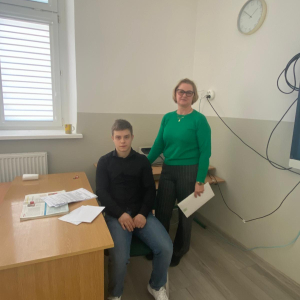 Uczeń klasy 8 wraz z nauczycielem od historii podczas prowadzenia lekcji.