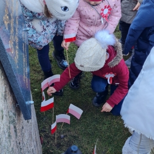 Dzieci zostawiają flagi przy kamieniach „Alei Chwały”